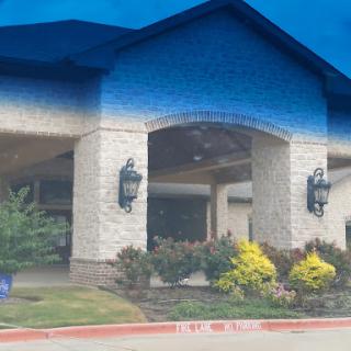 A beautifully designed entrance of a building surrounded by well-maintained landscaping.
