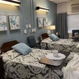 A well-organized hospital room with two beds, side tables, and decor.