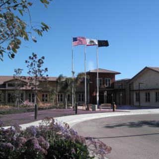 A sunny day at a building entrance with flags waving prominently.