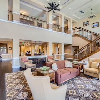 A spacious and inviting lobby featuring comfortable seating and a stylish staircase.