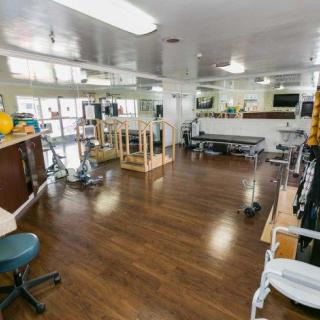 A rehabilitation center with various exercise equipment and therapy stations.