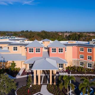 Aerial view of a colorful building with landscaped surroundings and a prominent entrance.