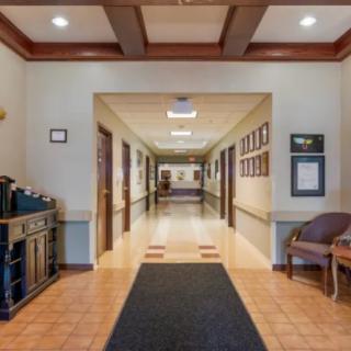 A well-lit office hallway featuring wooden accents and seating arrangements.