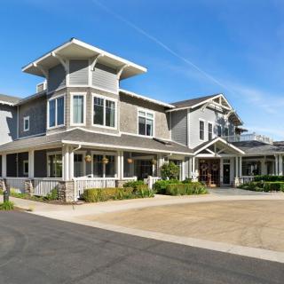 A modern residential building with a stylish architectural design and clear blue skies.