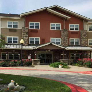 A multi-story residential building with a landscaped entrance.