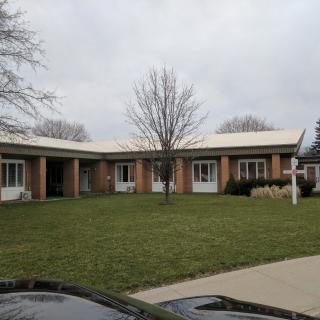 A suburban house with a well-maintained lawn and overcast sky.