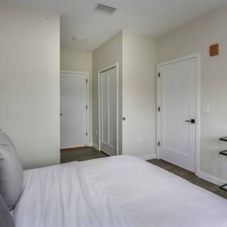 A minimalist bedroom with white walls and modern decor.