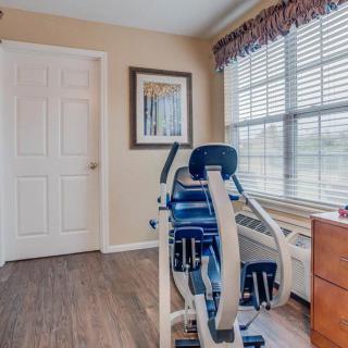 A small home gym with fitness equipment and a large window providing natural light.