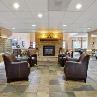 A cozy lobby with a fireplace and comfortable seating.