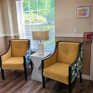 A cozy corner with two yellow armchairs and a modern lamp by the window.