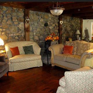 A cozy living room with stone walls, comfortable couches, and warm lighting.