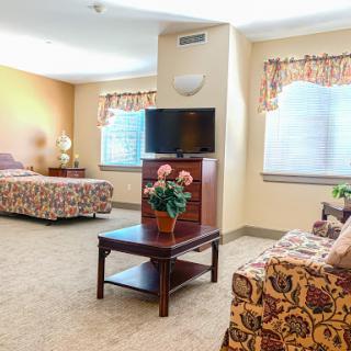A cozy and bright living space featuring comfortable furniture, a television, and a welcoming atmosphere.