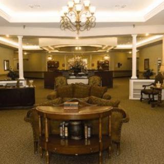 A spacious and elegant lobby featuring classic furniture and a grand chandelier.