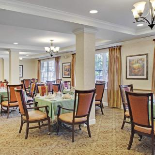 A well-lit dining area with neatly arranged tables and chairs.