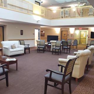 A spacious lobby with comfortable seating arranged for a meeting or gathering.