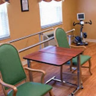 A rehabilitation room featuring exercise equipment and seating arrangements for physical therapy.