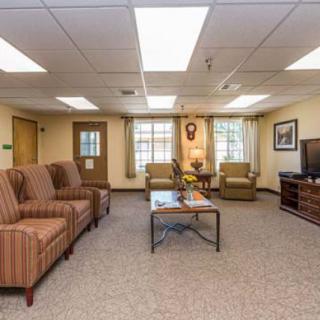 A cozy living room with comfortable seating, a television, and natural lighting.