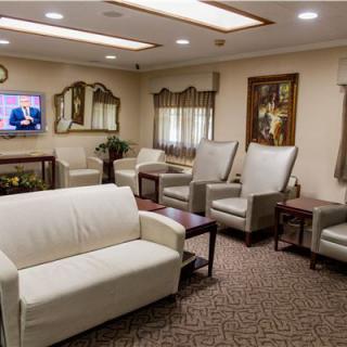 A well-furnished waiting room with comfortable seating and a television.