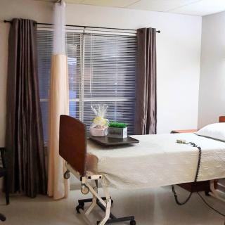 An empty hospital room with a patient bed and medical equipment.
