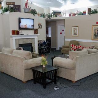 A cozy living room with couches, a fireplace, and a television.
