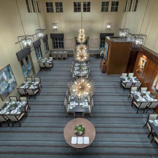 An elegant dining area with neatly arranged tables and exquisite chandeliers.