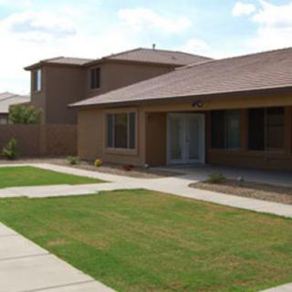 A suburban two-story house with a well-maintained lawn and driveway.