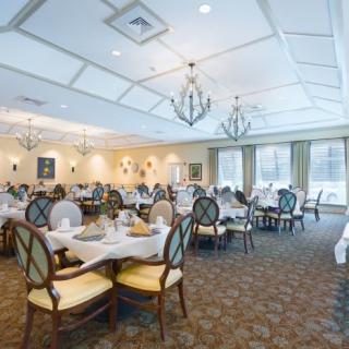 Elegant dining room with neatly arranged tables and chandeliers.