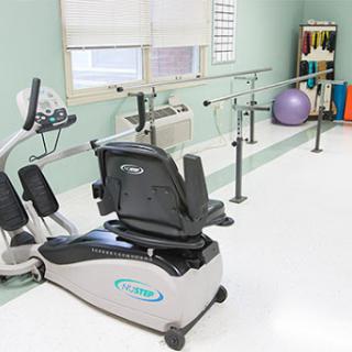 A well-equipped physical therapy room featuring various exercise equipment for rehabilitation.