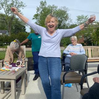 A joyful gathering in a garden with people socializing and celebrating.