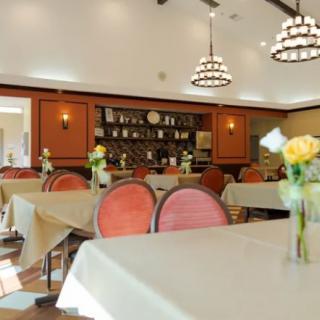 A cozy dining room with elegantly set tables and ambient lighting.