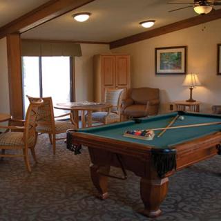 A cozy game room with a pool table and comfortable seating.