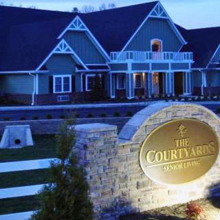 An evening view of a hotel building with illuminated sign and lights.
