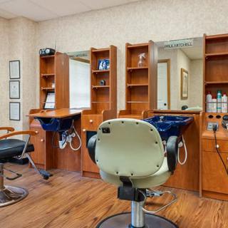 An interior view of a hair salon with styling stations and barber chairs.