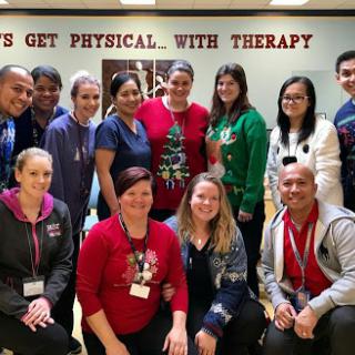 A joyful gathering of physical therapy professionals celebrating their teamwork and holiday spirit.