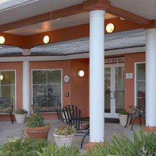 A building entrance with columns and outdoor seating.