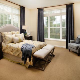 Modern and cozy bedroom with elegant decor and large windows.