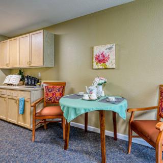 A cozy kitchen and dining area with a small table, chairs, and decorative elements.