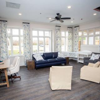 A well-lit living room with modern furniture and large windows.