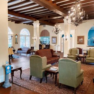 A spacious lobby with comfortable seating and elegant chandeliers.
