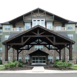 A modern building with a prominent wooden entrance and stone accents.