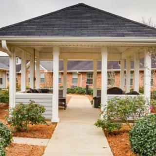A charming gazebo surrounded by neatly landscaped gardens and a clear pathway.