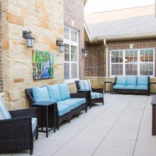 A cozy patio area with comfortable blue-cushioned seating and decorative lanterns.