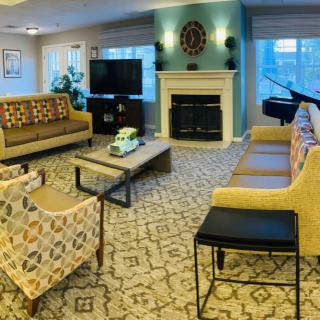 A cozy living room with modern decor, featuring a fireplace, comfortable seating, and a television.