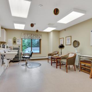 A well-lit doctor's office with seating and medical equipment.
