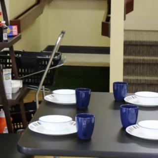 A dining area with a set table and adjacent stairs.