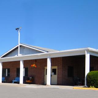 A welcoming entrance to a modest building under a clear blue sky.