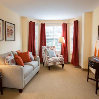 A cozy living room with a sofa, an armchair, and warm-colored decor.