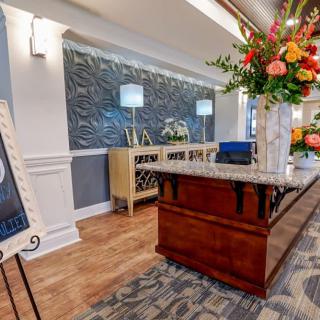 A modern and stylish lobby with a reception desk adorned with flowers.