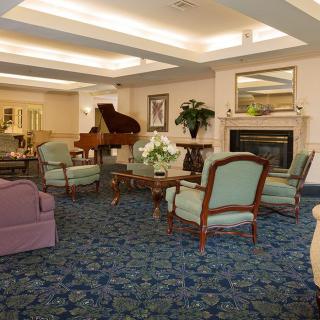 Elegant living room with a grand piano and comfortable seating.