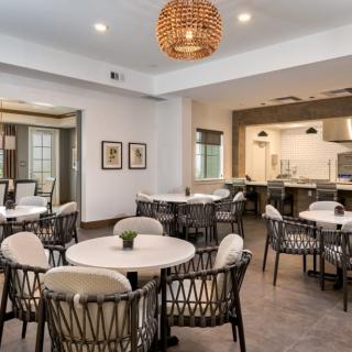 A modern dining area featuring round tables, cushioned chairs, and ambient lighting.